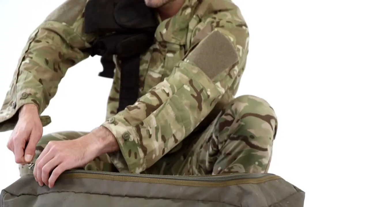 Soldier packing bag on white background