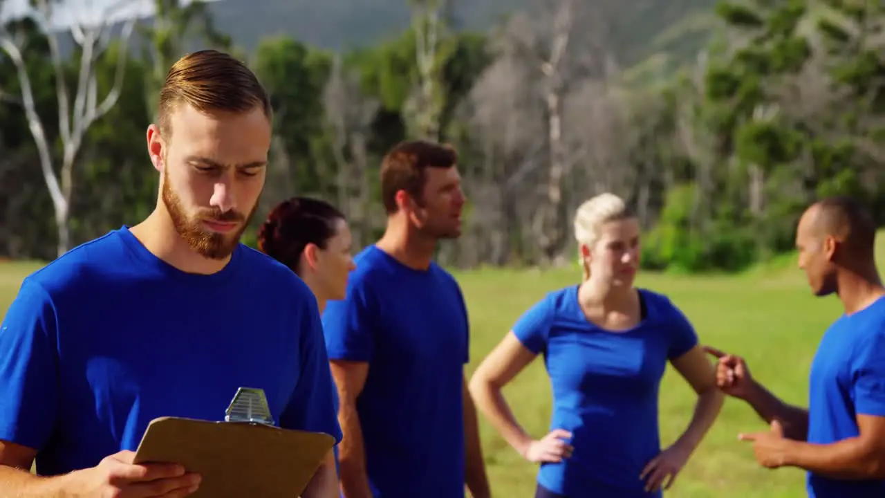 Man standing and holding a clipboard in boot camp 4k