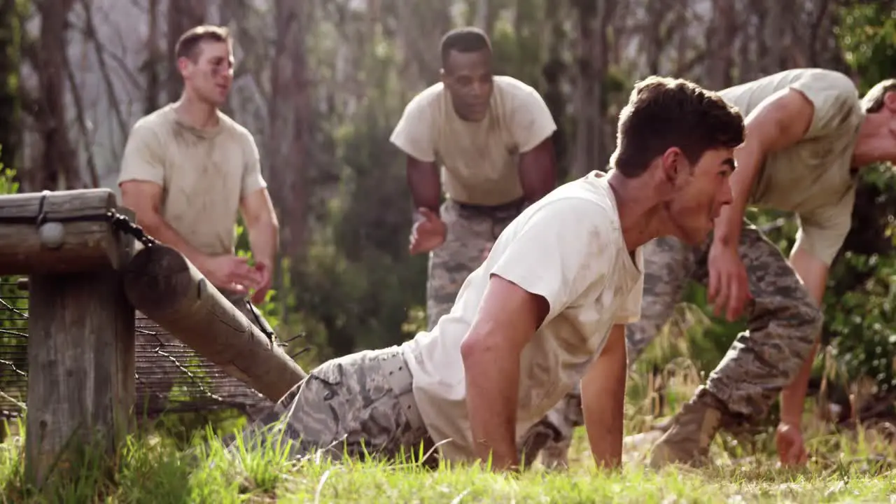 Military soldiers crawling under the net during obstacle course 4k