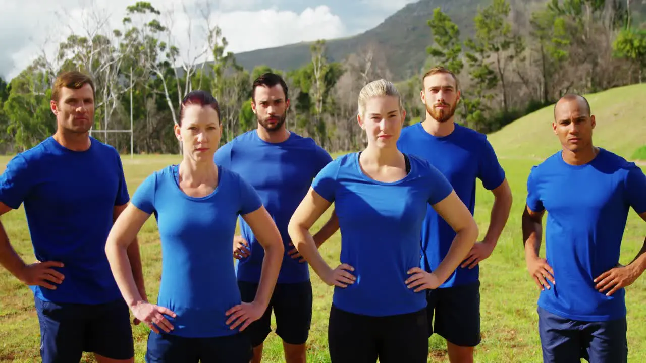 Group of people standing with hands on hip in boot camp 4k