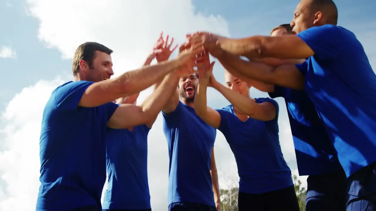 Group of people forming hand stack in boot camp 4k