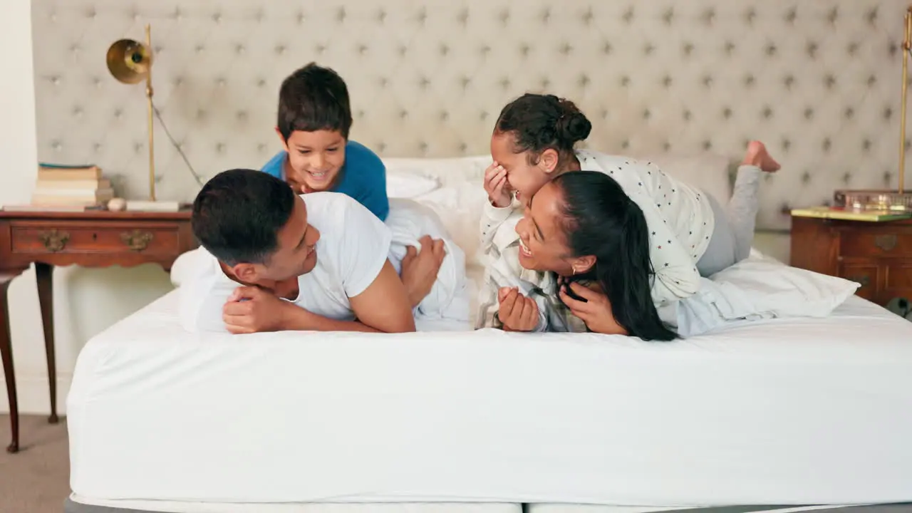 Happy family mom and dad with children on bed