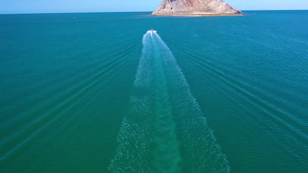 A boat travels to an island with survivors