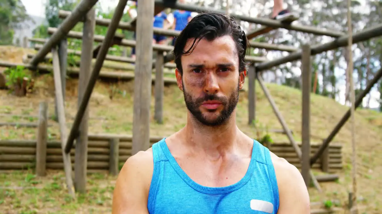 Fit man standing with arms crossed in boot camp 4k