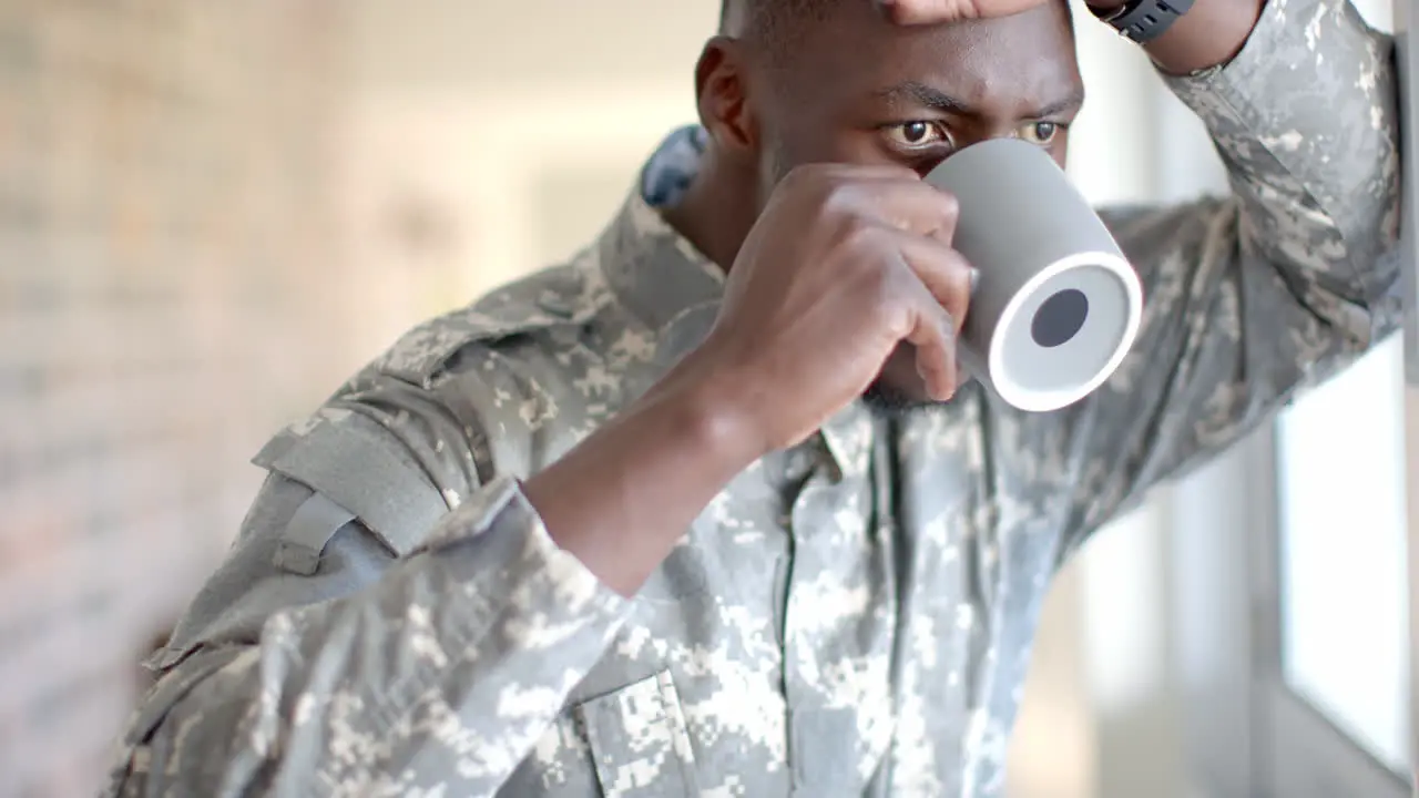 Young African American soldier in military uniform enjoys a coffee at home