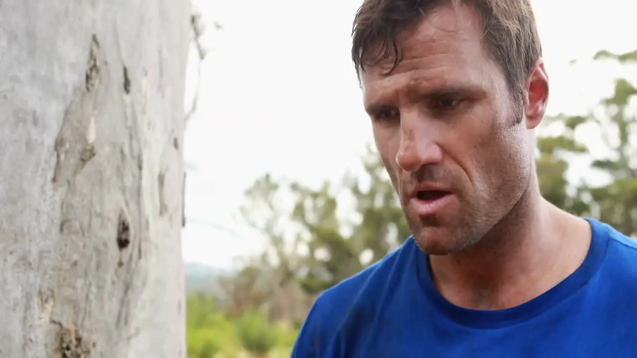 Fit man pouring water after workout during obstacle course