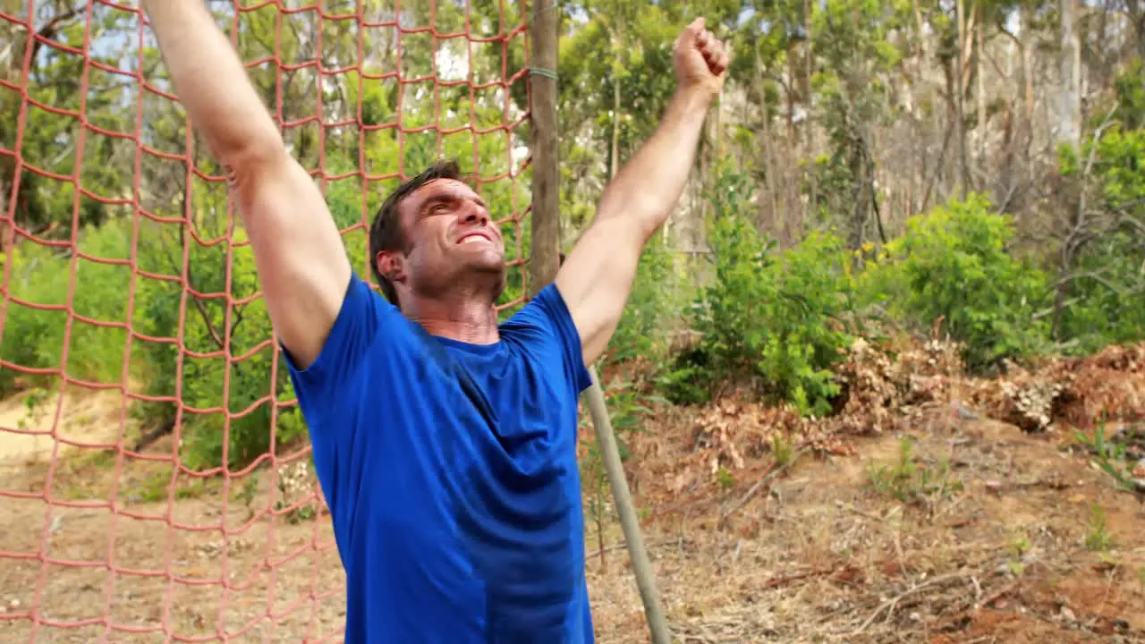 Fit man cheering during obstacle course