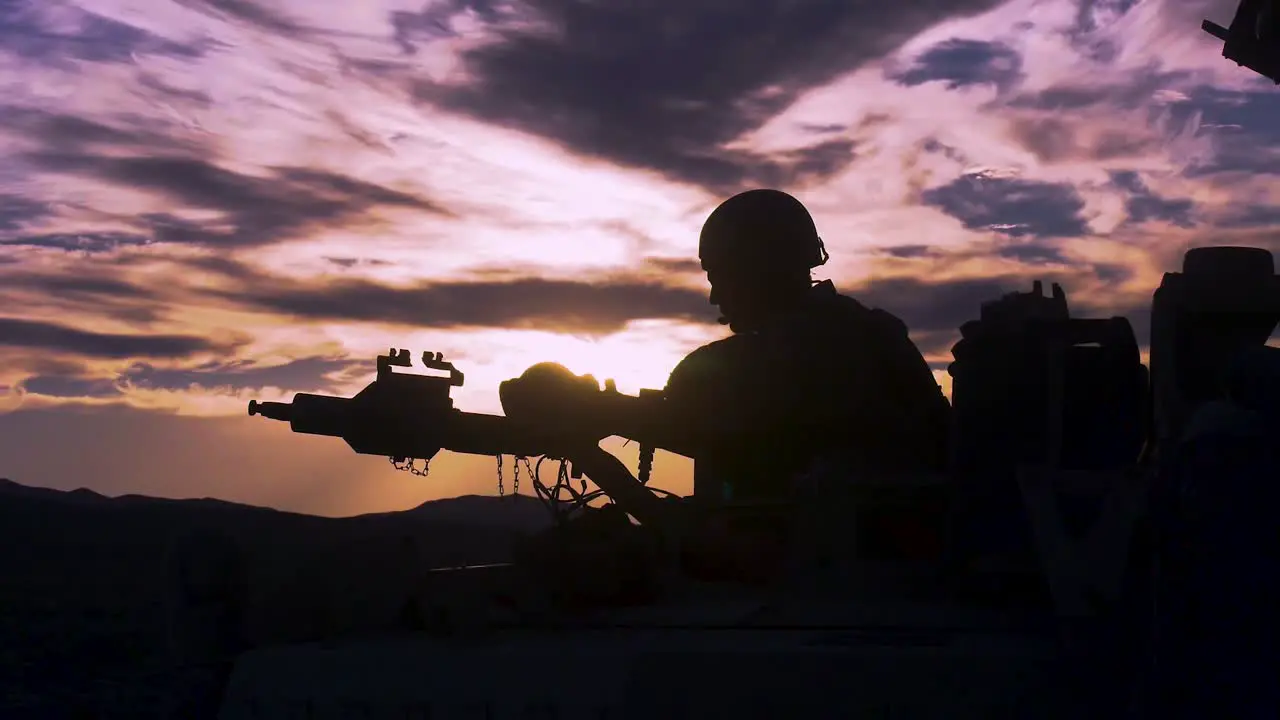 Silhouette Of A Soldier On A Machine Gun On Top Of A Tank Against A Sunset 2019