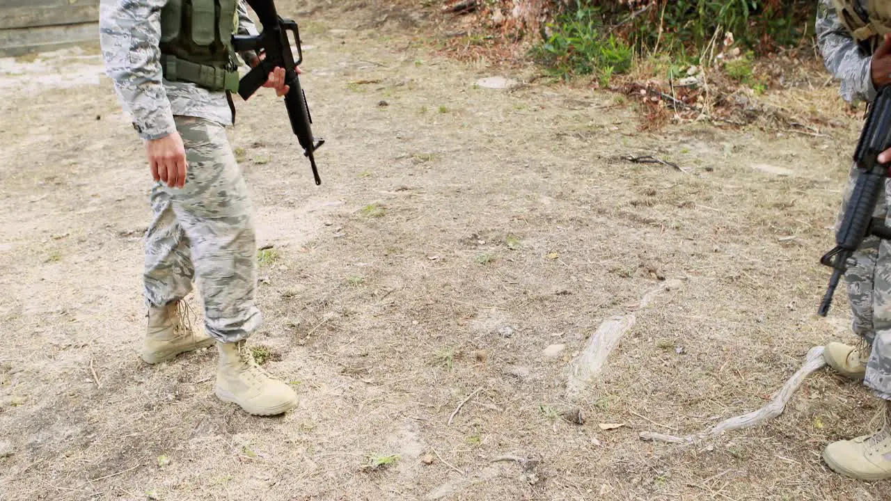 Soldier carrying an injured soldier during training exercise with weapon