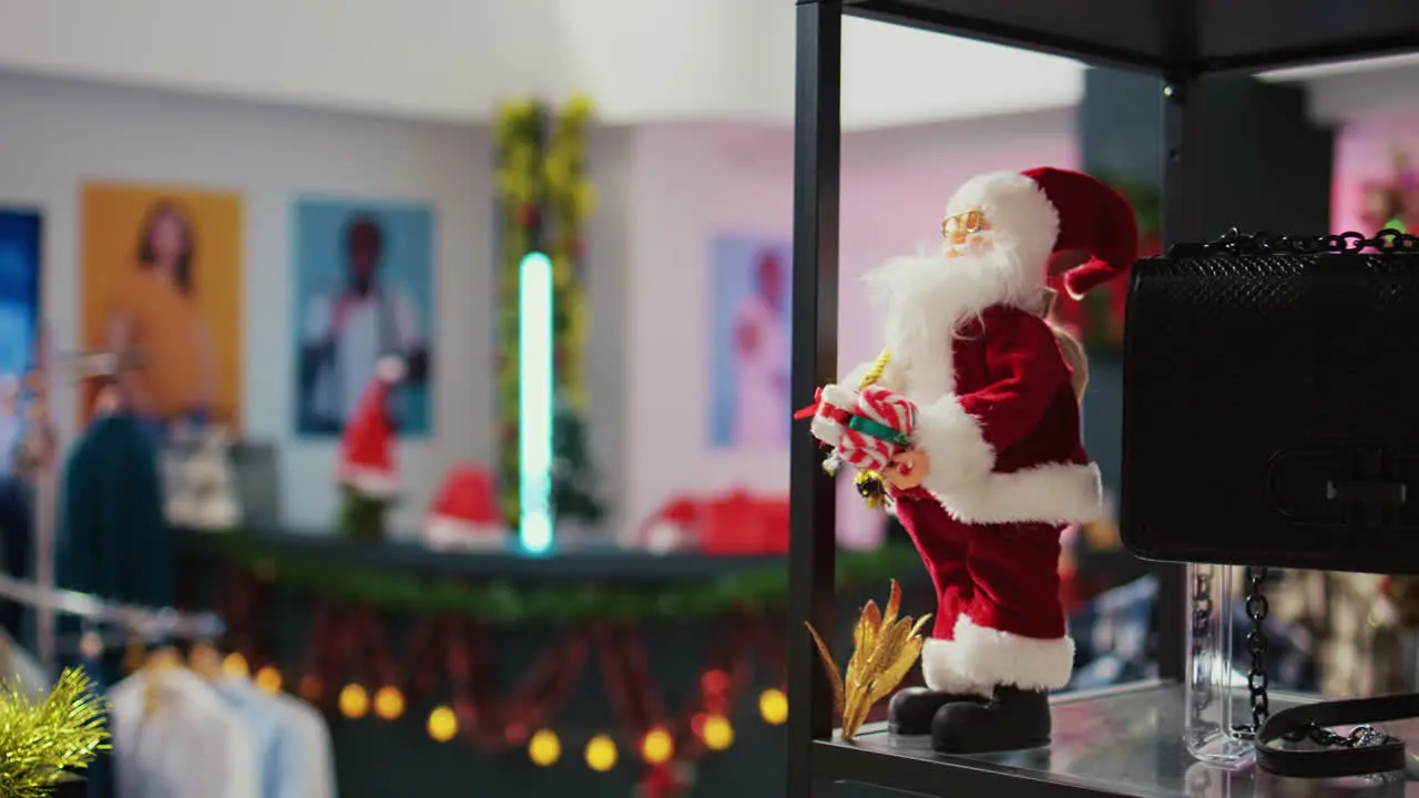 Close up panning shot of miniature Santa Claus figure used as Christmas decoration in empty fashion boutique during winter holiday season Xmas ornaments in clothing store