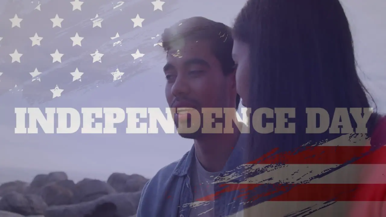 Animation of usa flag effect and independence day text against biracial couple talking at the beach