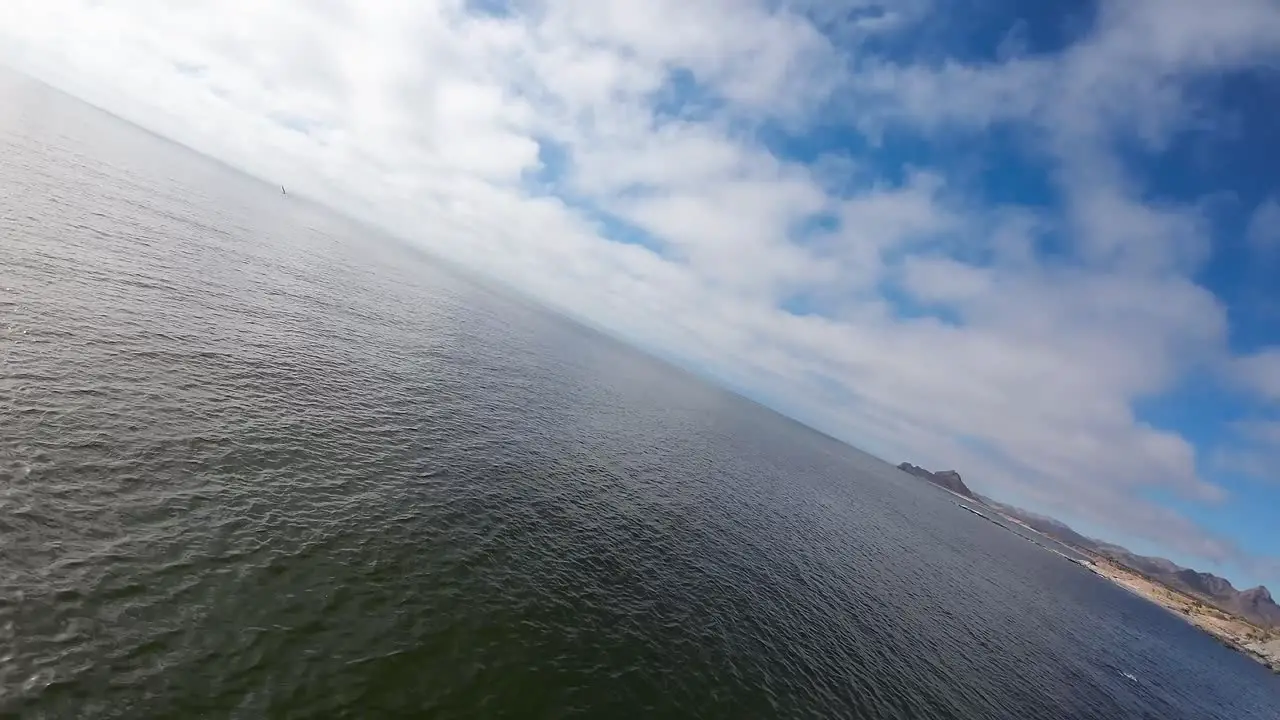 Aerial drone shot at low altitude by the sea at a maximum inclination