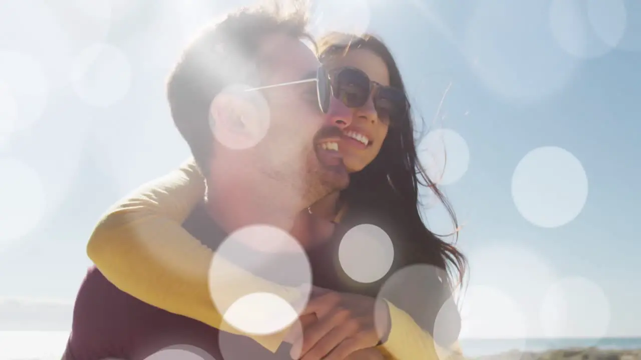 Animation of dots over happy caucasian couple having fun on beach