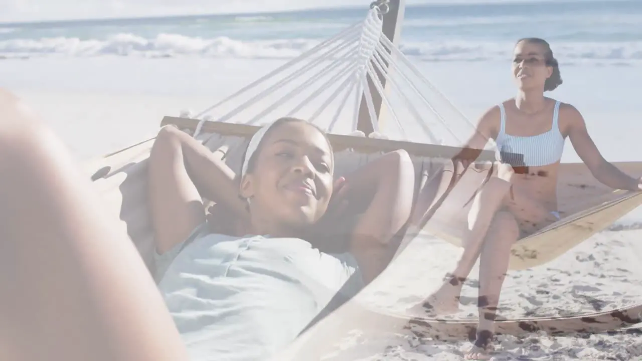 Animation of happy african american woman in hammock on beach