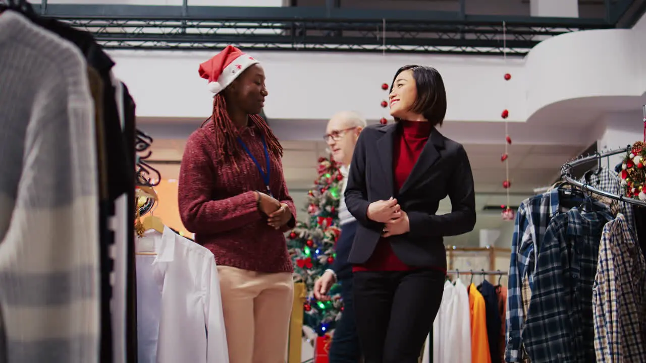 Ground level shot of customer spinning around in festive decorated clothing store excited to show african american employee elegant blazer fitting perfectly after trying it on