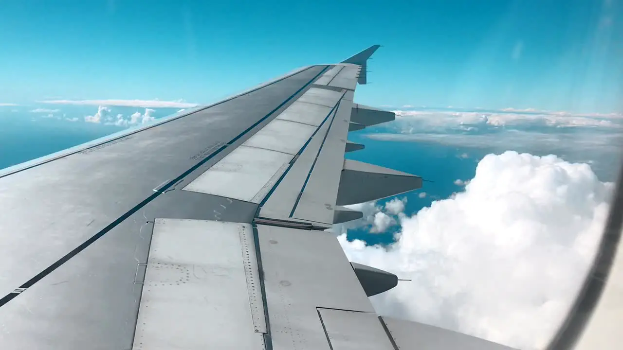 Plane Wing against clouds and a blue sky