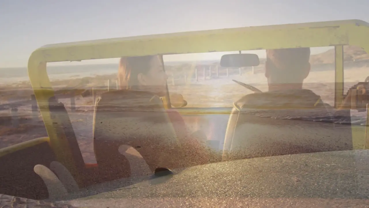 Animation of light over happy caucasian couple in car on beach