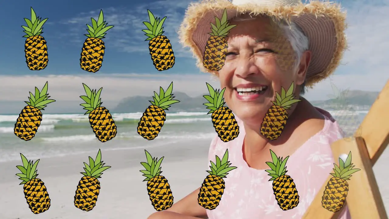 Animation of pineapple over happy senior biracial woman sunbathing on beach