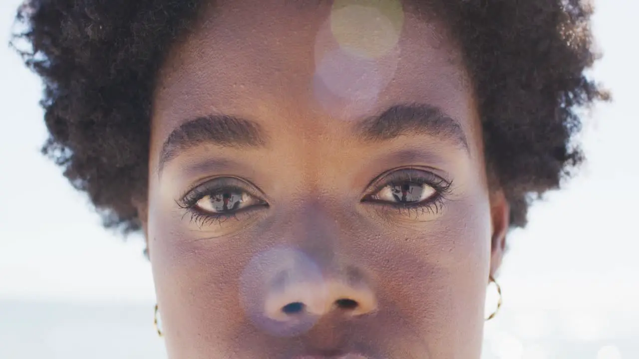 Video of face of happy african american woman looking at camera on beach