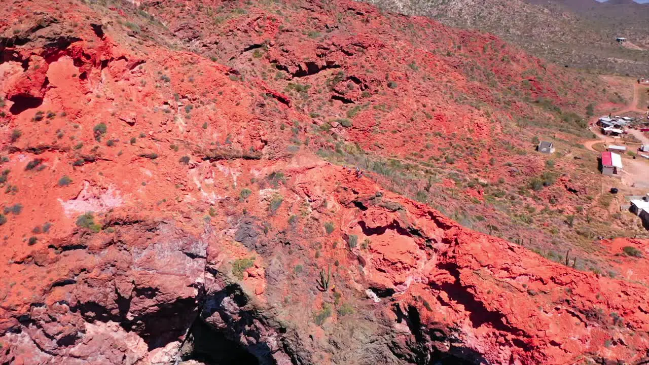 People climbing red mountain on the beach