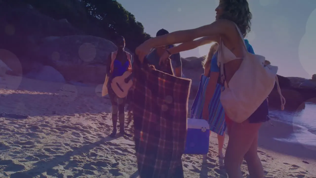 Animation of glowing lights over group of diverse female friends on beach by the sea