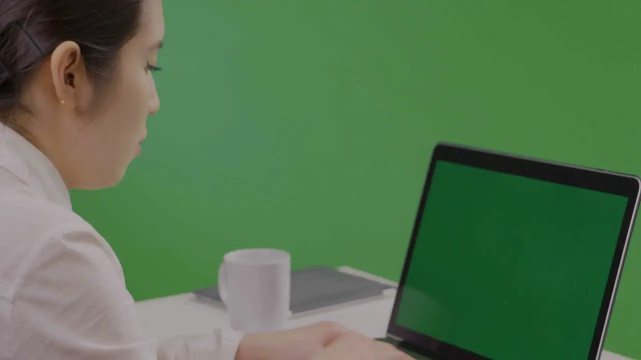 CU Woman Typing on Laptop on Green Screen