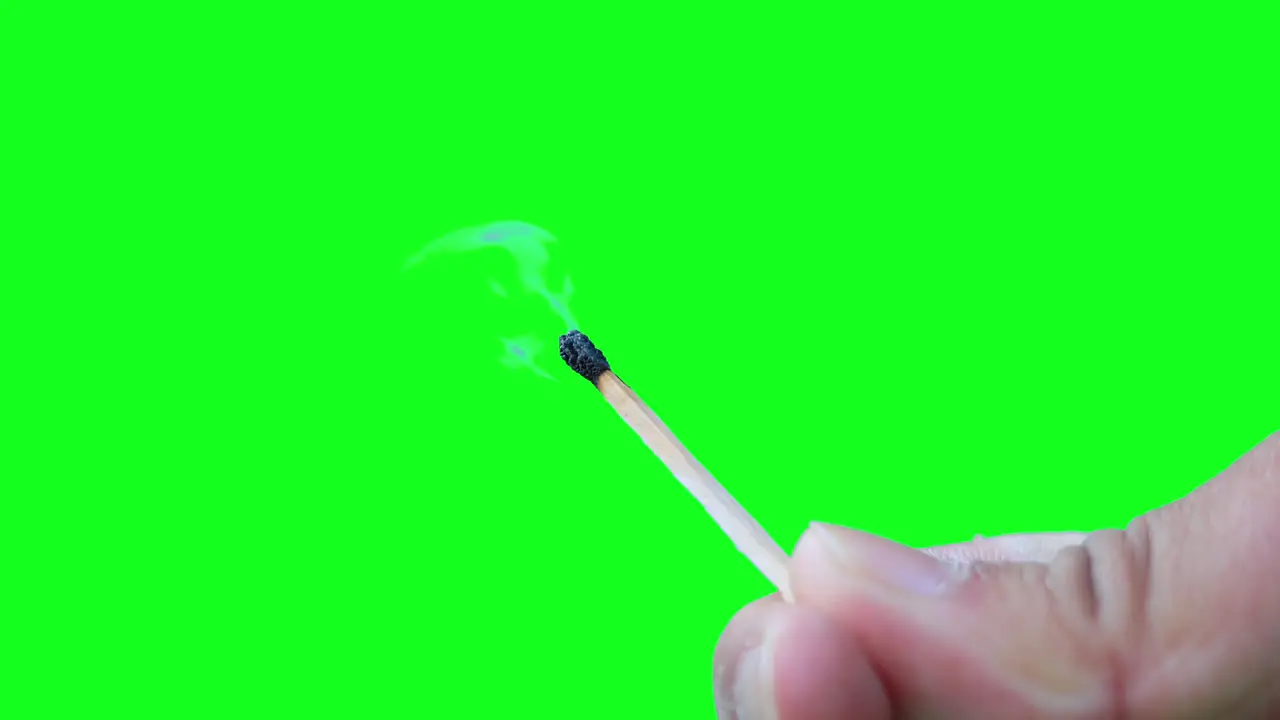 Closeup hands hold burning matchstick against green screen