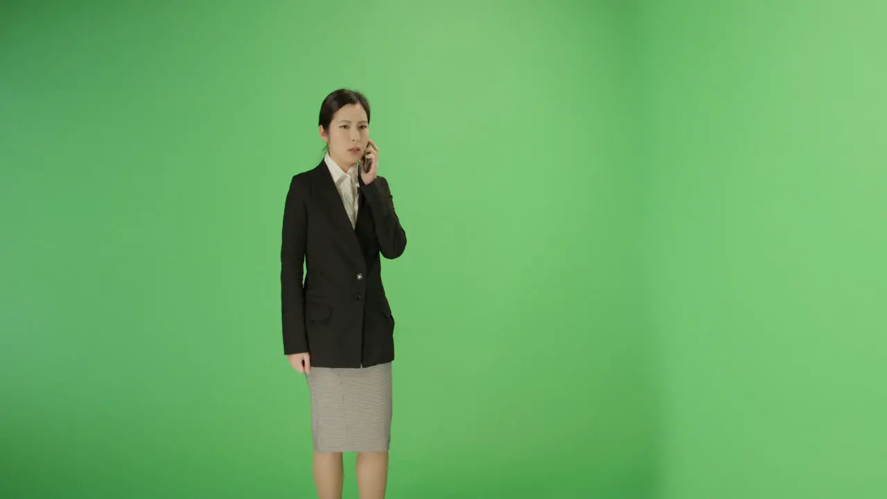 Serious Businesswoman answer phone on green screen