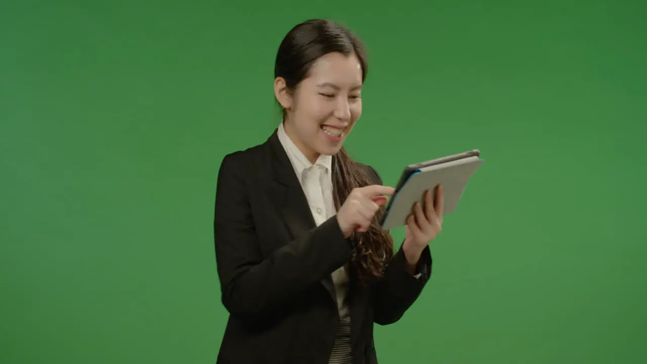 Laughing Businesswoman Uses Tablet on Green Screen