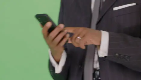 CU Businessman texting while walking on green screen