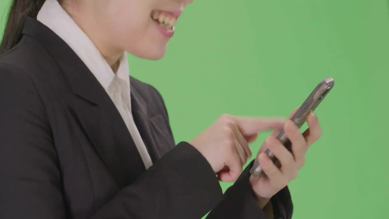 CU Smiling Businesswoman using phone with green screen