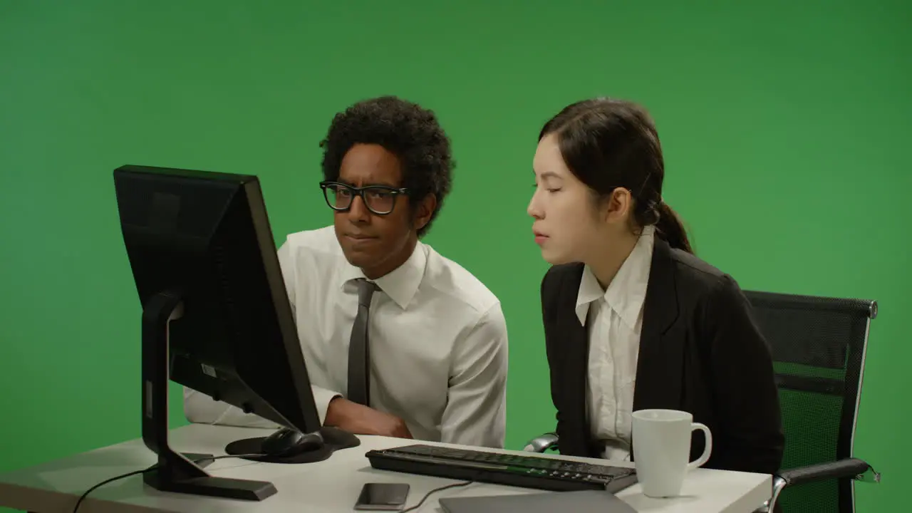 Two Colleagues Look Concerned at Computer on Green Screen