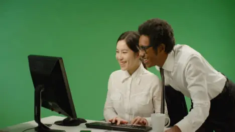 Happy Businessman Checking on Woman at Computer