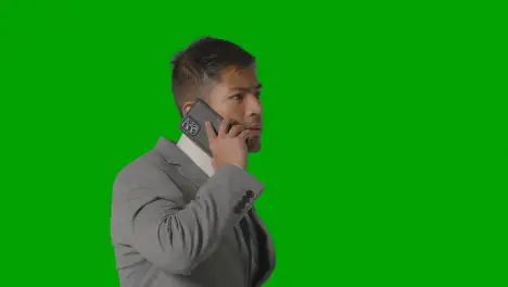 Studio Shot Of Serious Businessman In Suit Taking Call On Mobile Phone Against Green Screen 2