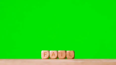 Business Concept Wooden Letter Cubes Or Dice Spelling Fail Against Green Screen