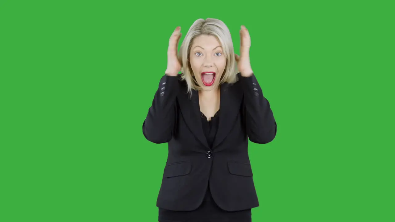 Attractive blonde woman in front of chroma key green screen is happy surprised and shocked