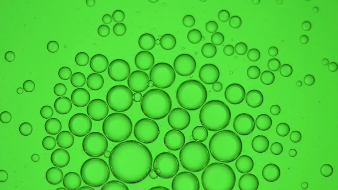 Group of small bubbles on a green screen 4K Macro