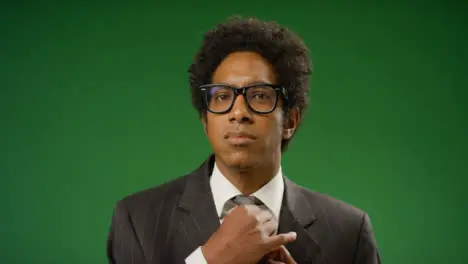 Portrait of Businessman adjusting tie on green screen