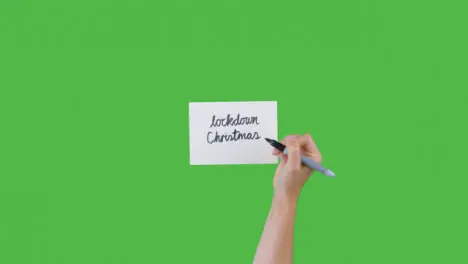 Woman Writing Lockdown Christmas on Paper with Green Screen