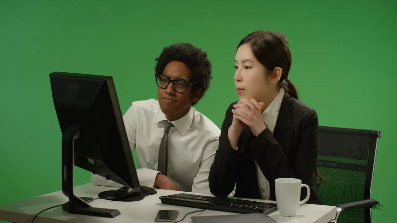 Two Colleagues Look Worried at Computer on Green Screen