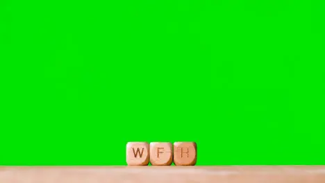 Business Concept Wooden Letter Cubes Or Dice Spelling WFH Against Green Screen