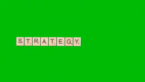 Stop Motion Business Concept Overhead Wooden Letter Tiles Forming Word Strategy On Green Screen 1