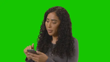 Frustrated Woman Looking At Mobile Phone Against Green Screen 1