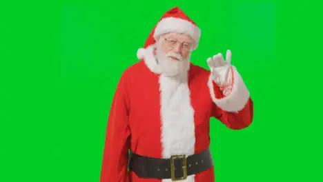 Portrait Shot of Santa Waving Hello to Camera with a Green Screen