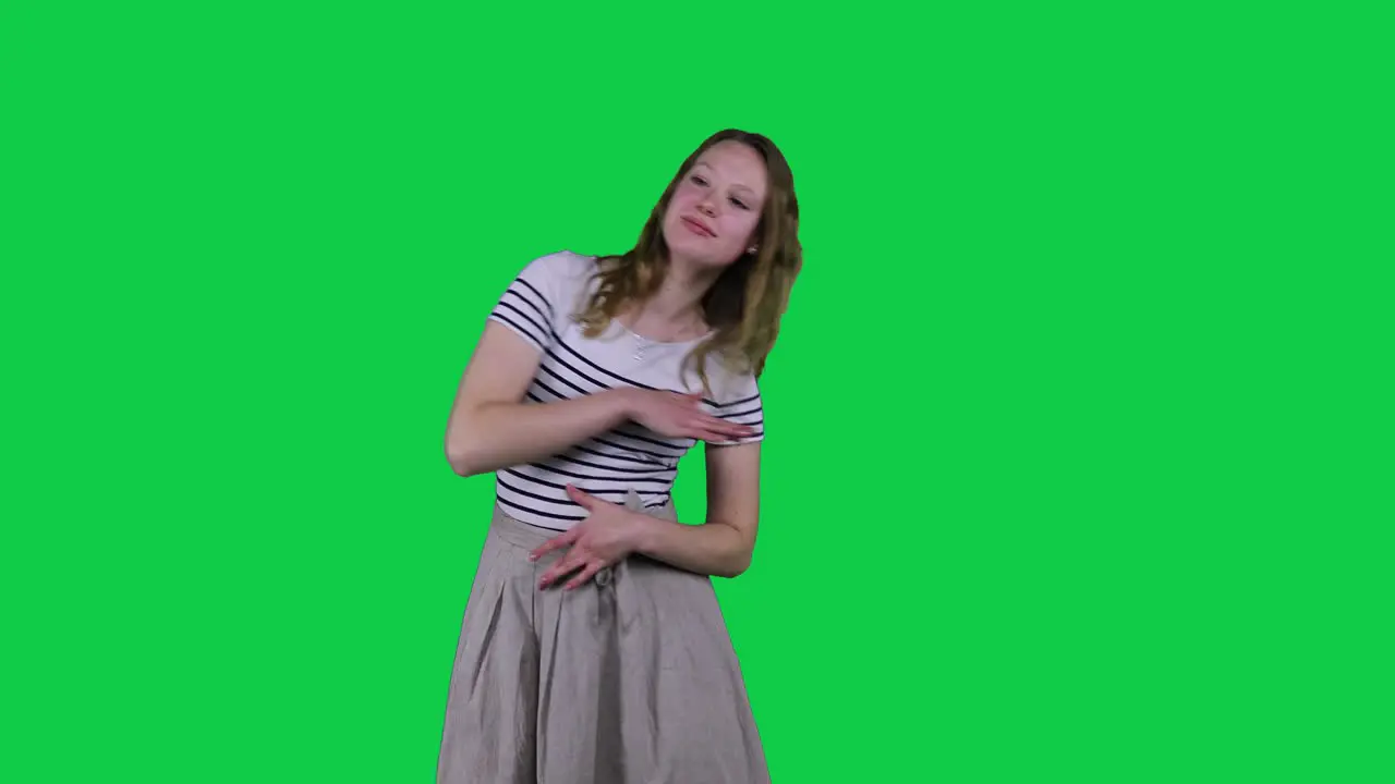 Happy teenage girl dancing in front of a green screen