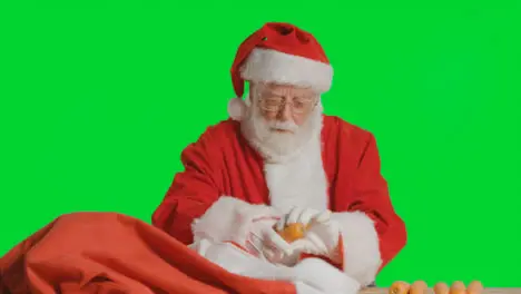 Portrait Shot of Santa Pulling Carrots Out from Sack In Front of Green Screen 