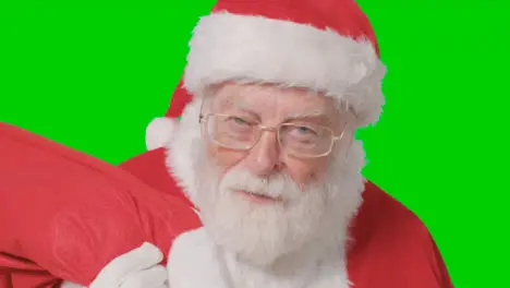 Close Up Shot of Santa Walking Into and Out of Frame Holding Sack with Green Screen