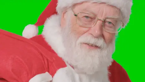 Close Up Shot of Santa Walking Into and Out of Frame Holding a Sack with Green Screen