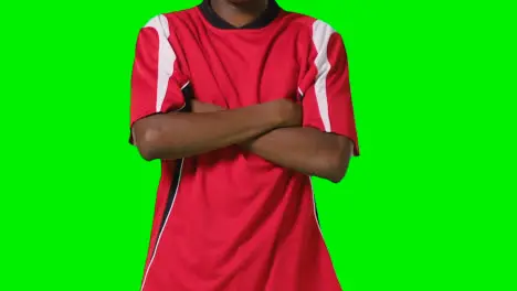 Close Up Studio Shot Of Male Footballer Warming Up With Exercises Before Game Against Green Screen