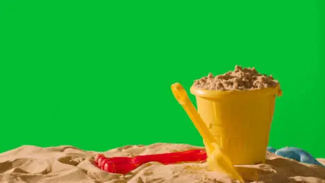 Summer Holiday Concept With Child's Bucket Spade On Sandy Beach Against Green Screen 1